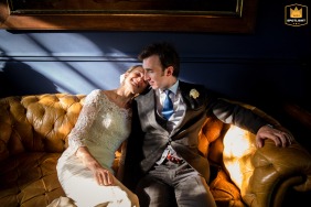   Seated together on a sofa at a church near Chateau de Lartigolle in Gers, France, the couple enjoys side by side time in the sunlight amid their special day.